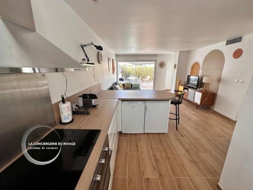 une cuisine avec des armoires blanches et un plancher en bois dans l'établissement Le Malibu - Port de Carqueiranne - Tout à pied, à Carqueiranne