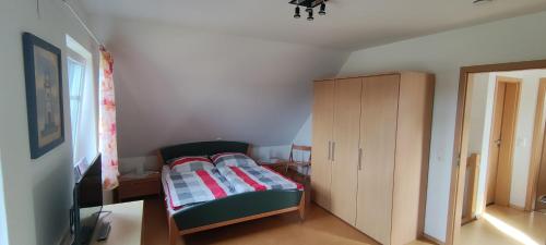 une petite chambre avec un lit et une armoire dans l'établissement Ferienhaus Wangermeer, à Wangerland