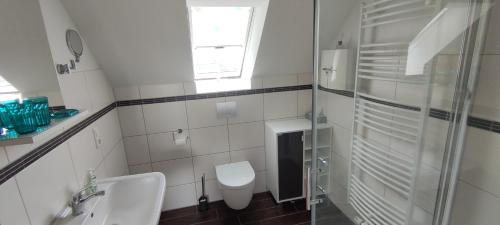 une salle de bains blanche avec toilettes et lavabo dans l'établissement Ferienhaus Wangermeer, à Wangerland
