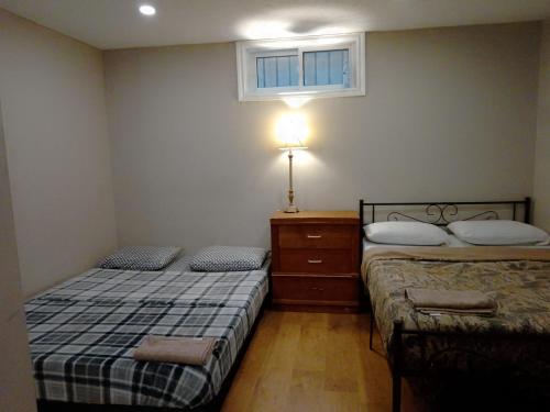 a bedroom with two beds and a lamp and a window at Cheap Rooms in Kitchener Best For Students ,Long Term Guests in Kitchener
