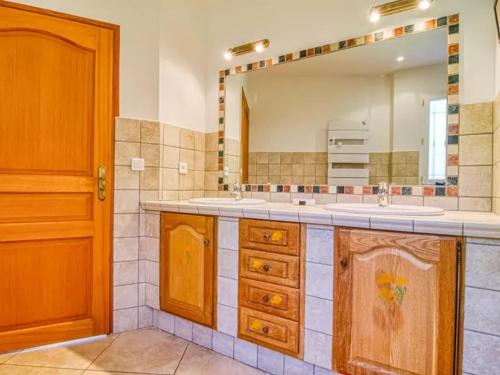 une salle de bain avec un lavabo et un grand miroir dans l'établissement Villa Faro Provence Var, à Montfort-sur-Argens