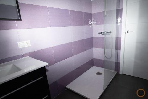 a purple and white bathroom with a shower and a sink at Home Turia Pio Apartamento de 3 habitaciones in Valencia
