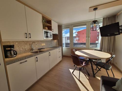 - une cuisine avec une table, une table et des chaises dans l'établissement PLA 2 07 - Beautiful apt 4pers - Val Claret-Tignes- with garage, à Tignes