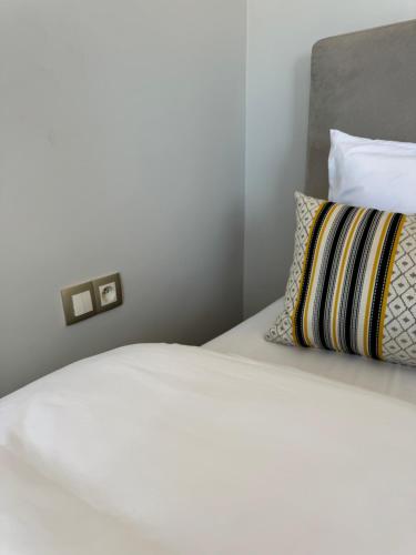 a bedroom with a white bed with a pillow at Ksar Labhar Second Nest in Rabat