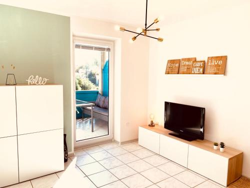 a living room with a tv and a couch at Gemütliches Apartment mit Fernblick Kamin Balkon in Zwiesel
