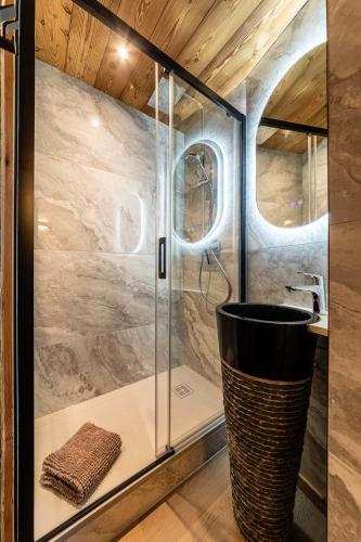 une douche en verre dans une salle de bain avec un lavabo dans l'établissement L Eden - Immodreams - Avoriaz, à Avoriaz