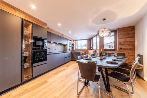 une cuisine et une salle à manger avec une table et des chaises dans l'établissement L Eden - Immodreams - Avoriaz, à Avoriaz