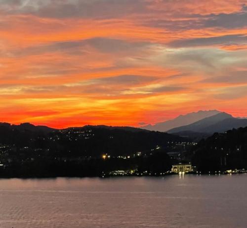 a sunset over a lake with mountains in the background at La Terrazza sul Lago di Como con garage in Blevio