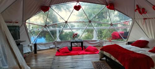 a bedroom with a large window in a tent at Glamping Eco Azulejo in Arbeláez