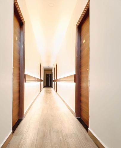 an empty hallway with wooden doors and a long corridor at Chamundi Comforts in Hassan