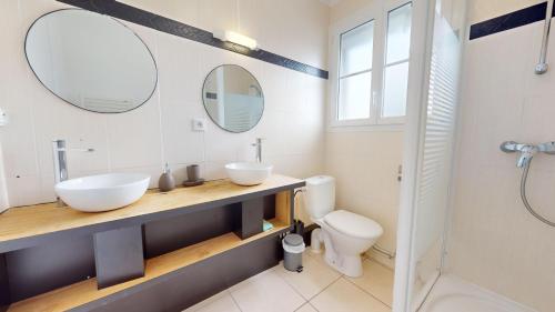 Un baño con dos lavabos y un inodoro. en Etoile des Mers, en Plage-des-Demoiselles