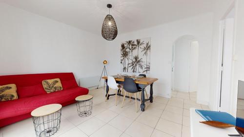 Una sala de estar con un sofá rojo y una mesa. en Etoile des Mers, en Plage-des-Demoiselles