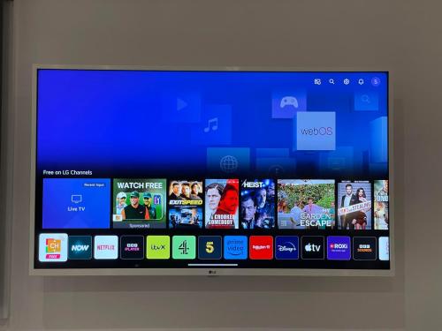 a television screen with a bunch of videos on it at Heathrow Airport 10 mins drive l FREE SECURE PARKING l Tiny House with Courtyard in New Bedfont