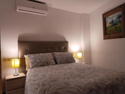 a bedroom with a bed with two lamps on night stands at Reyes in Monachil