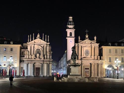 a building with a clock tower in a city at night at Casa Florian in Turin