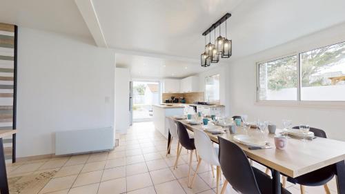 une cuisine et une salle à manger avec une table et des chaises dans l'établissement Le Chant des Vagues, à Saint-Jean-de-Monts