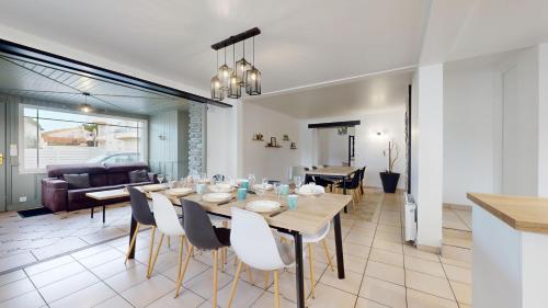une salle à manger et un salon avec une table et des chaises dans l'établissement Les Flots des Demoiselles, à Saint-Jean-de-Monts