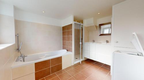 un baño con bañera y lavabo en Les Flots des Demoiselles, en Plage-des-Demoiselles