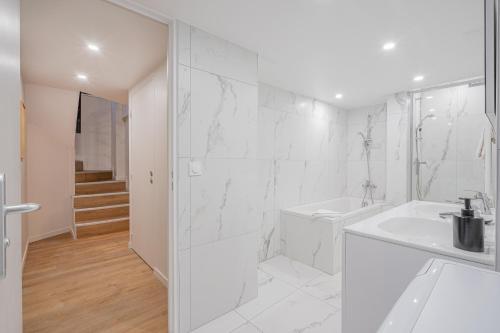 a white bathroom with a sink and a shower at Résidence Le Belleville in Paris