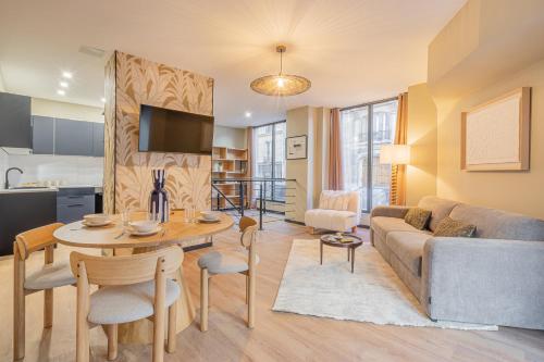 un salon avec un canapé et une table dans l'établissement Résidence Le Belleville, à Paris