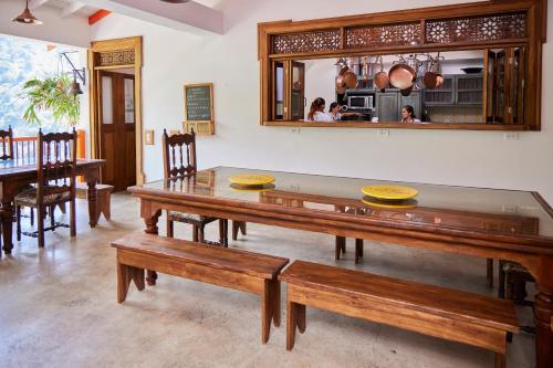 a dining room with a table and benches at Finca La Manchuria in Salgar