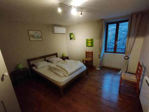 a bedroom with a bed and a large window at Gîte les Dames - Mens in Mens