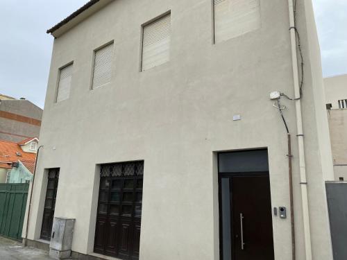 a white building with a door and two windows at Firstfloorby22 in Matosinhos
