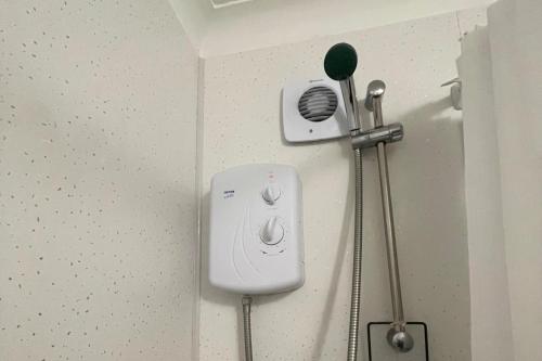 a hair dryer on the wall of a bathroom at 3-Bed House Sleeps 5 w Garden Parking & Pets Ok in Norwich