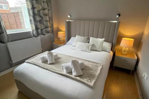 a bedroom with a large white bed with towels on it at 3-Bed House Sleeps 5 w Garden Parking & Pets Ok in Norwich