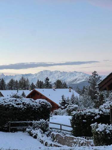 a snow covered yard with mountains in the background at Apartment with a garden, close to golf in Lens