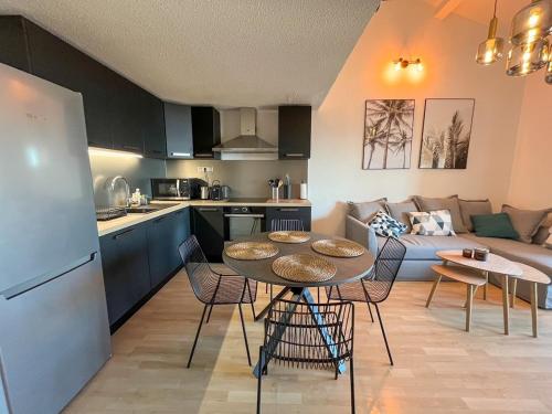 une cuisine et un salon avec une table et des chaises dans l'établissement Entre Ciel et Mer - Vue panoramique - Plages à 1km, à Carqueiranne
