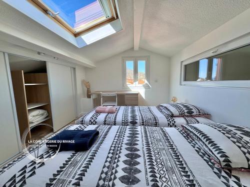 - une chambre avec 2 lits et une lucarne dans l'établissement Entre Ciel et Mer - Vue panoramique - Plages à 1km, à Carqueiranne