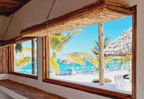 a window in a room with a view of the beach at Aquamarina Hotel in Jambiani