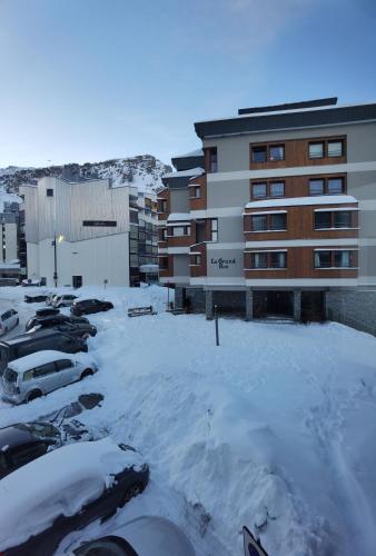 un parking couvert de neige à côté d'un bâtiment dans l'établissement MyHome - PSO37 - Studio cosy 4 pax Val Claret, à Tignes