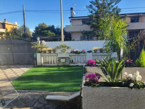 a backyard with a yard with grass and flowers at Il sole di Roma in Casal Palocco
