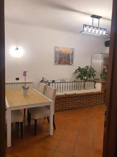 a dining room with a table and chairs and a bench at Il sole di Roma in Casal Palocco