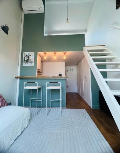 une chambre avec un escalier et une cuisine avec un comptoir dans l'établissement Cozy flat, à Paris