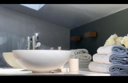 La salle de bains est pourvue d'un lavabo et d'un tas de serviettes. dans l'établissement Cozy flat, à Paris