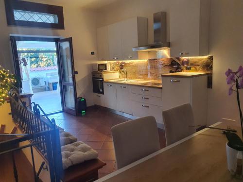 a kitchen with white cabinets and a table and chairs at Il sole di Roma in Casal Palocco