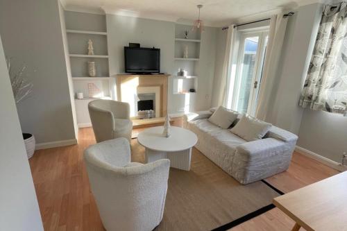 a living room with a couch and chairs and a tv at 3-Bed House Sleeps 5 w Garden Parking & Pets Ok in Norwich
