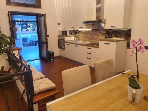 a kitchen with a table and chairs and a dining room at Il sole di Roma in Casal Palocco