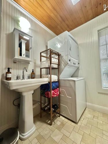 a bathroom with a sink and a washer and dryer at Bare Feet Bungalow -Close to beach & dog friendly in Gulfport