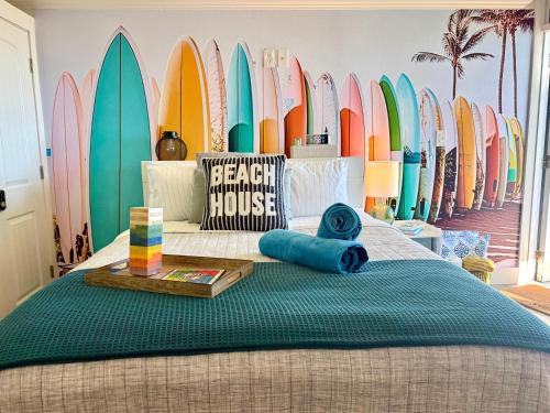 a room with a bed with a bunch of surfboards at Luxury Beachfront Studio - Private Balcony with Ocean View - Heated Pool - Hot Tub - Tiki Bar - Sauna in Daytona Beach