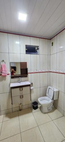 a bathroom with a toilet and a sink at Casa Lory in Angra dos Reis