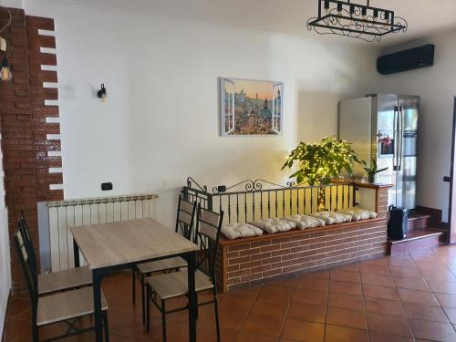 a dining room with a table and a bench at Il sole di Roma in Casal Palocco