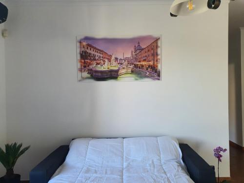 a white couch in a room with a painting on the wall at Il sole di Roma in Casal Palocco