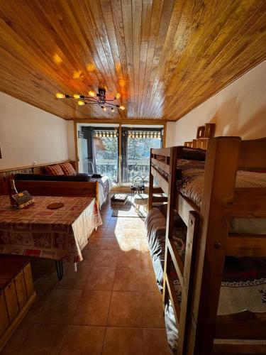 - une chambre avec des lits superposés et une table dans l'établissement Studio cosy à 5 min à pied des pistes, à La Salle Les Alpes