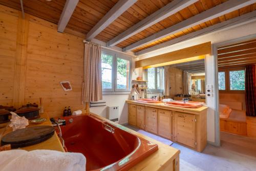 - une grande salle de bains pourvue d'une baignoire rouge dans l'établissement Chalet Des Drus, à Chamonix-Mont-Blanc