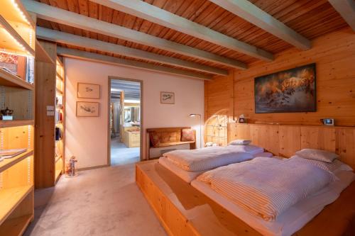 Cette chambre en bois comprend un grand lit. dans l'établissement Chalet Des Drus, à Chamonix-Mont-Blanc