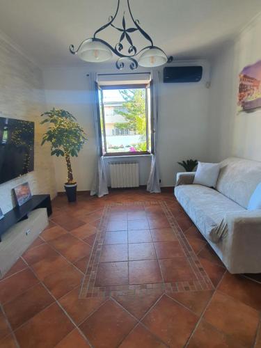 a living room with a couch and a window at Il sole di Roma in Casal Palocco